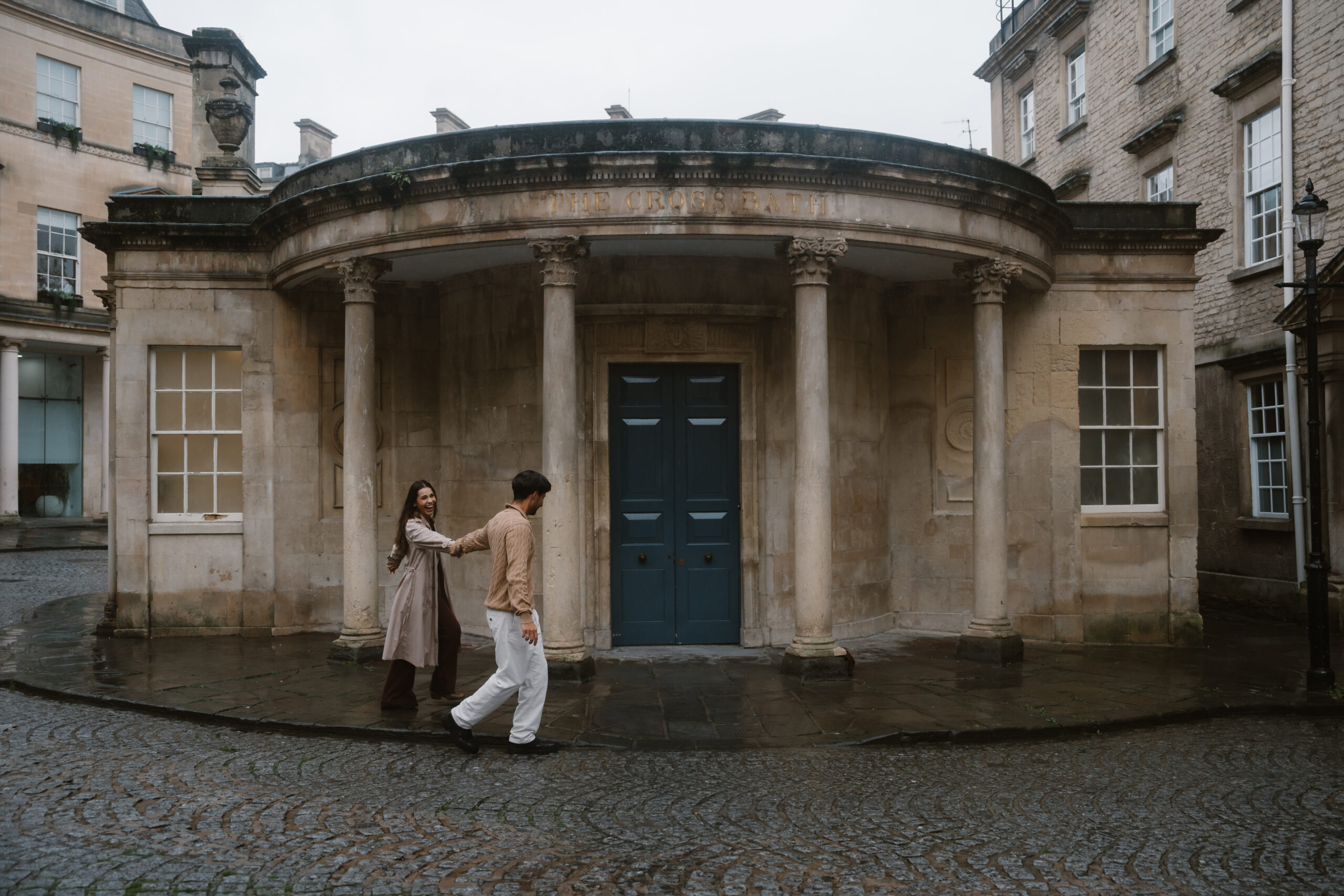 couple dancing in the rain outside of Bath Abbey in England